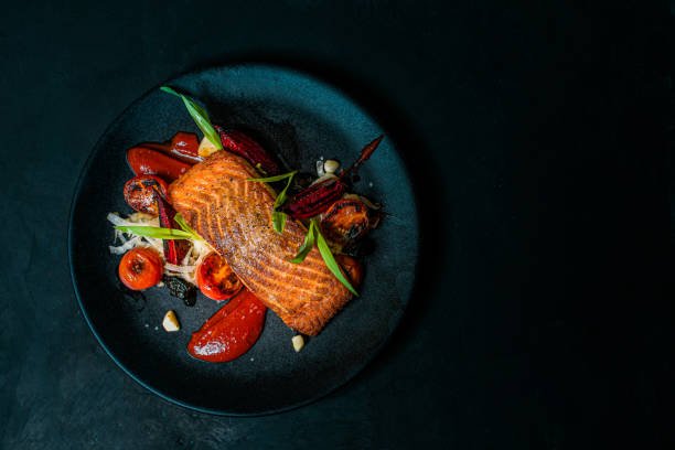 How to Choose the Freshest Fish at a Restaurant delicious meal on a black plate, top view, copy space.